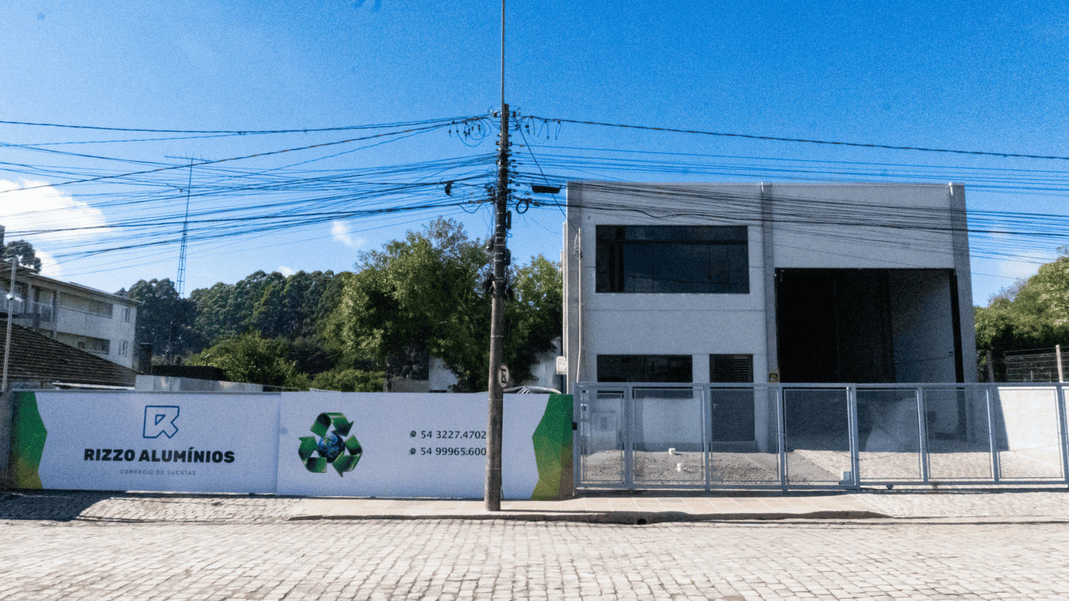 Caminhão descarregando sucata em pátio industrial ao entardecer